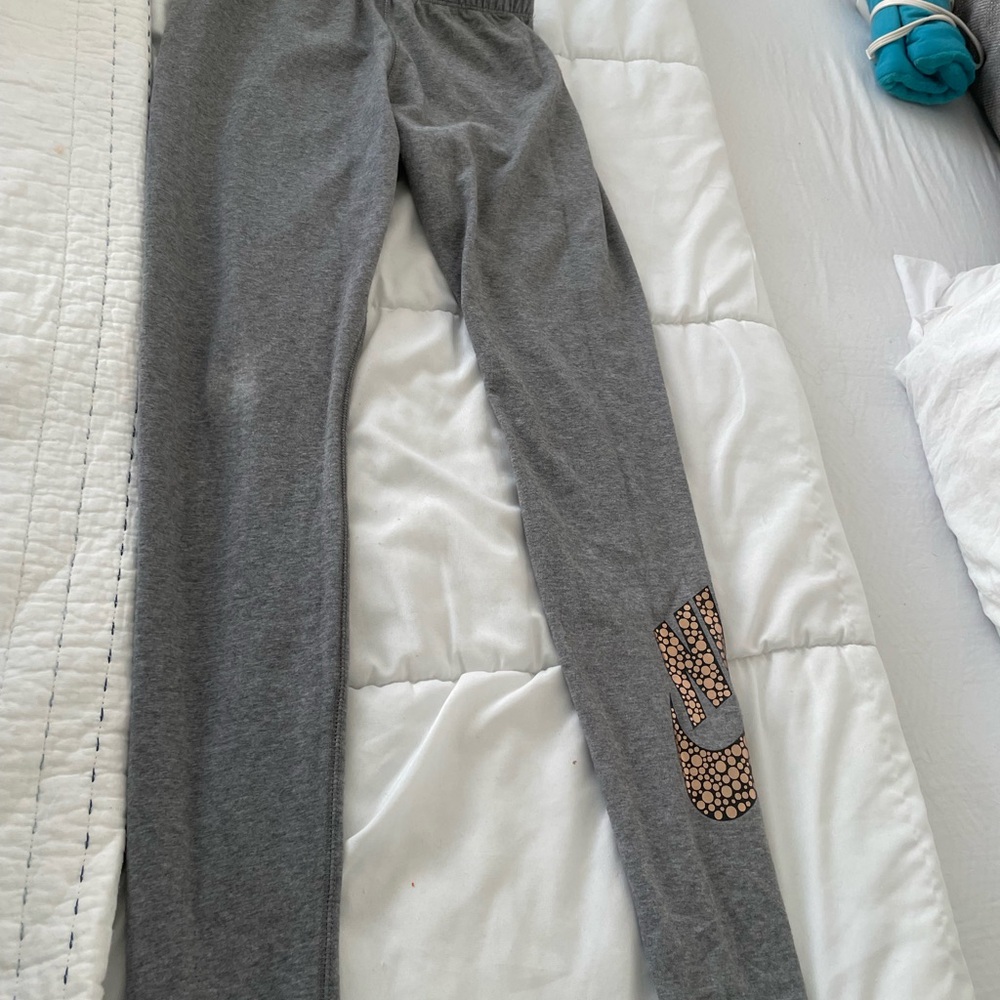 Nike Gray Leggings with Gold Logo on bottom pant leg. Inside fold over “just do